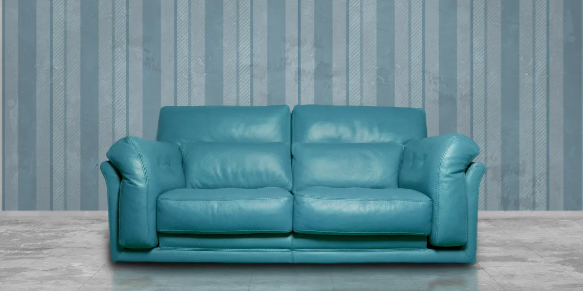 A modern turquoise leather sofa with sleek sofa upholstery, set against a striped, textured walls upholstery backdrop. The design highlights premium leather upholstery and elegant furniture upholstery solutions, perfect for enhancing contemporary living spaces in Bahrain.