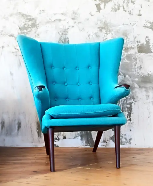 Stylish teal armchair with tufted backrest and wooden legs, showcasing premium sofa upholstery services in Bahrain by Home Decor. A perfect example of modern sofa designs and quality fabrics.