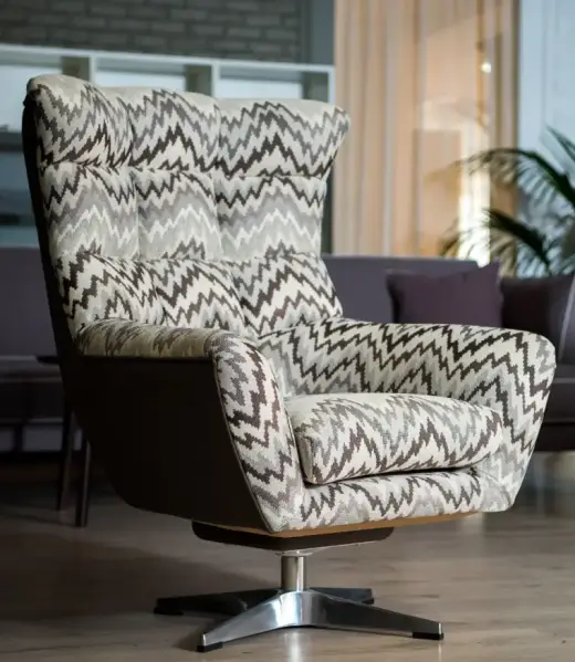 A stylish armchair with bold zigzag-patterned couch upholstery fabric, paired with a sleek wooden base and metal legs. Perfect for enhancing interiors with modern and timeless designs in Bahrain.